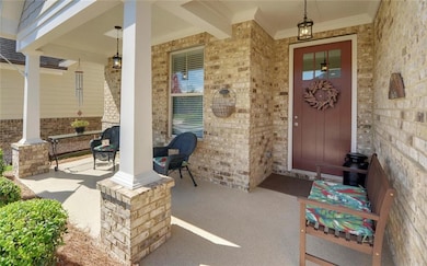 Doorway to property featuring a porch and brick siding
