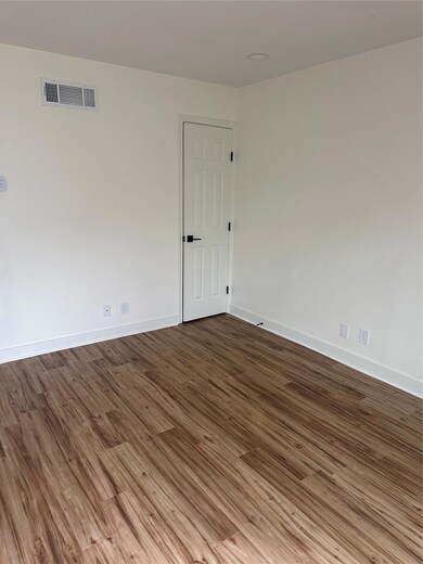 Empty room featuring wood finished floors and bas