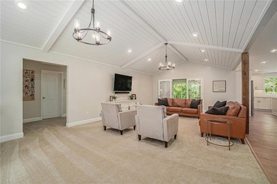 Living area featuring a chandelier, recessed lighting, baseboards, wooden ceiling, and light colored carpet