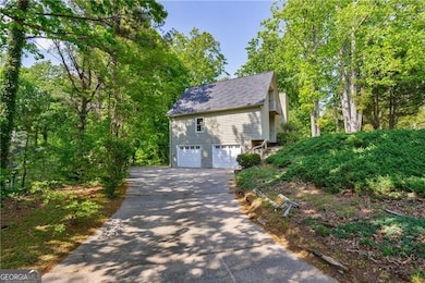 View of side of home featuring driveway, roof with