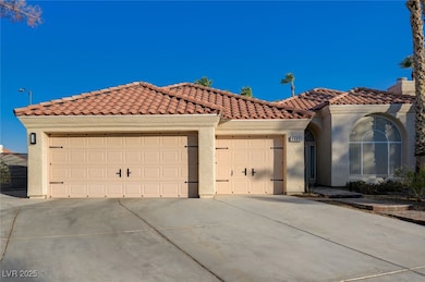Mediterranean / spanish house with a garage, driveway, stucco siding, and a tiled roof