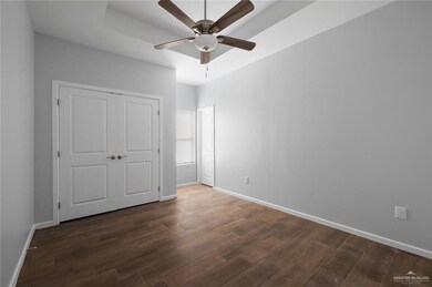 Unfurnished bedroom with dark hardwood / wood-style flooring, ceiling fan, and a closet