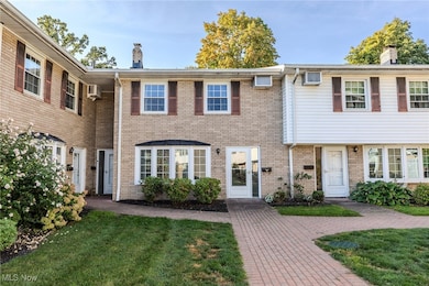 View of front of property featuring a chimney, a front yard, and brick siding
