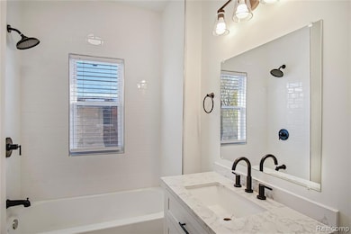 Bathroom featuring vanity and washtub / shower combination