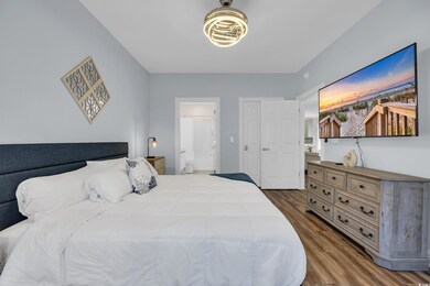 Bedroom with dark wood-style flooring and ensuite bathroom