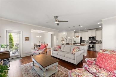 Living area featuring crown molding, dark wood fin