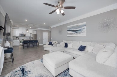 Living area with ornamental molding, recessed lighting, light wood-type flooring, and a ceiling fan