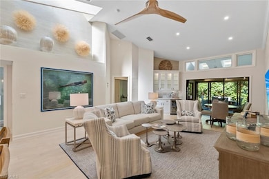 Living room with a high ceiling, ceiling fan, wine