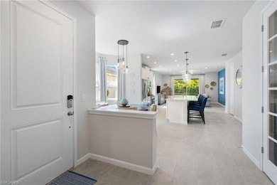 Foyer featuring baseboards, recessed lighting, and light tile patterned flooring