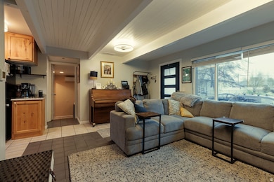 Living room with beam ceiling and light tile patterned floors