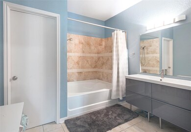 Bathroom with a textured wall, tile patterned flo