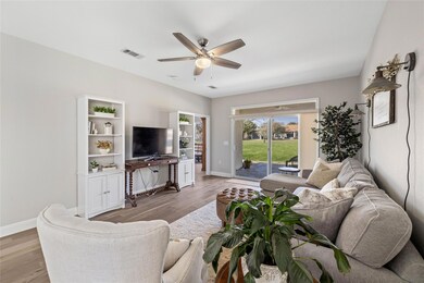 Living room with ceiling fan and wood finished fl