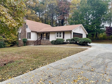 Single story home with covered porch, a front yard, a chimney, and view of scattered trees