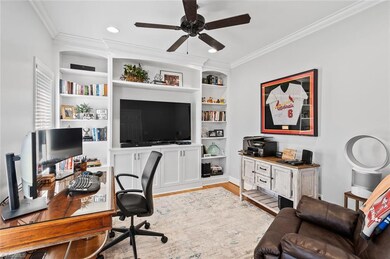 Living room/Office is to the left of the foyer and features can lighting, ceiling fan, crown molding, hardwood flooring and custom built in cabinetry.