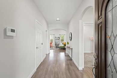 Welcoming entry hall with modern wood-look flooring and a direct view into the bright, open-concept living area.