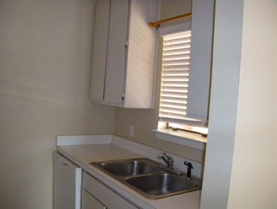 Kitchen with white cabinets, a sink, light counte