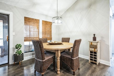 Dining space featuring a chandelier, dark wood fi