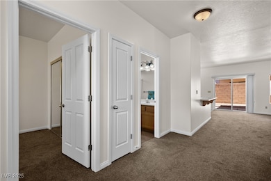 Hallway with a sink, baseboards, dark colored carp
