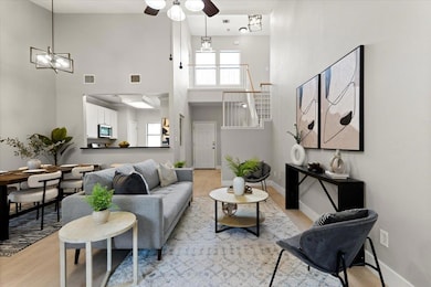 Living room featuring a high ceiling, ceiling fan
