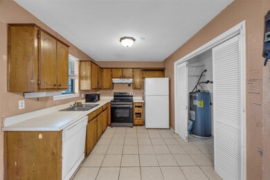 Kitchen with sink, light tile patterned floors, wh
