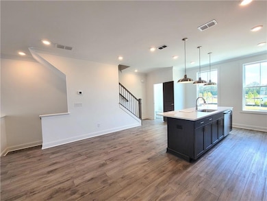 Kitchen with a center island with sink, wood finis
