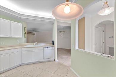 Kitchen featuring light countertops, white cabinetry, dishwasher, light tile patterned flooring, and pendant lighting