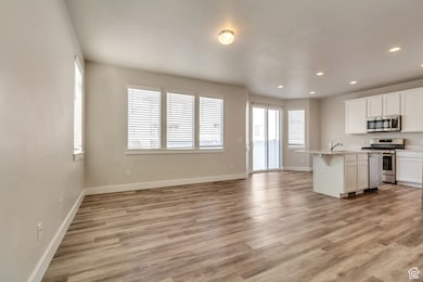 Unfurnished living room featuring light wood-type flooring and recessed lighting