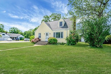 Cape cod-style house with a front lawn and roof with shingles