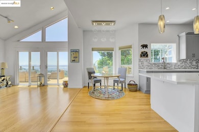 Kitchen featuring light countertops, light wood finished floors, decorative backsplash, gray cabinetry, and recessed lighting