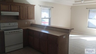 Kitchen with tile flooring, a healthy amount of sunlight, ventilation hood, and white electric range oven