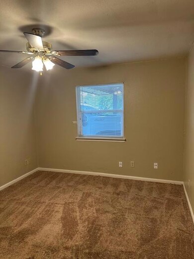 Spare room featuring carpet, ceiling fan, and bas