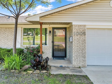 Doorway to property with a garage, brick siding, a