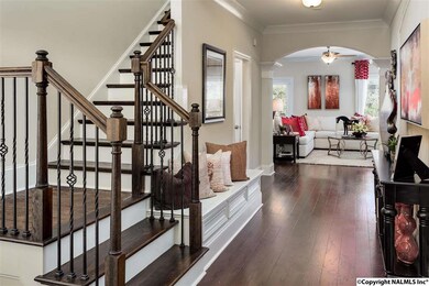 This gorgeous foyer welcomes you with a two story ceiling, a welcome bench, decorator molding, and this gorgeous wood staircase.