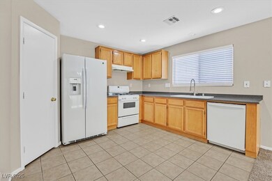 Kitchen with white appliances, a sink, under cabin