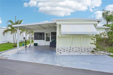 Mobile home with entry steps, a carport, and a sunroom
