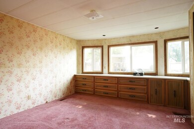 Spare room featuring carpet and wallpapered walls