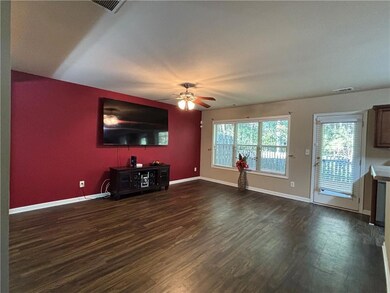 Unfurnished living room with dark wood-style floors and a ceiling fan