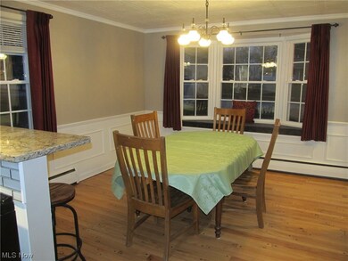 Dining area with recently refinished hardwood floor, original wainscoting, and bay window with window seat, updated lighting, freshly painted. Large pantry/cabinet can be included if requested to stay.