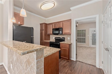 Kitchen with black appliances, dark hardwood / woo