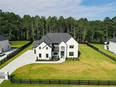 Aerial view of property and surrounding area featuring a forest