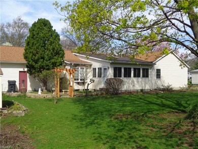 Back view, patio, heated sun room w/skylight.