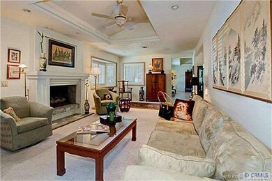 Family room with high ceilings, fan & fireplace.