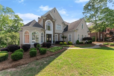 View of front of home with a shingled roof, stucco
