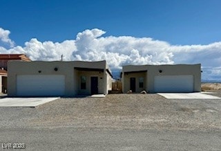 Pueblo-style home featuring a 2-car garage, drivew