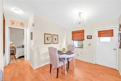 Dining area featuring light wood-type flooring, a textured ceiling, and a chandelier