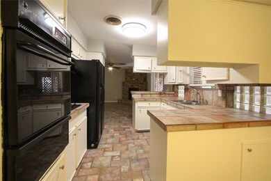 Kitchen features black appliances including a gas stove top, single oven and refrigerator.