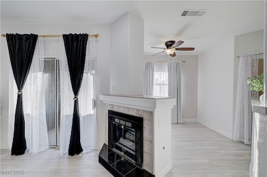 Unfurnished living room featuring light wood finished floors, a fireplace, and ceiling fan