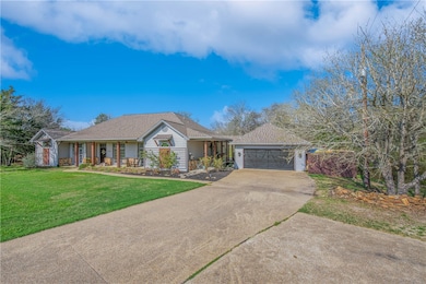 Ranch-style home with a front lawn, a porch, a gar