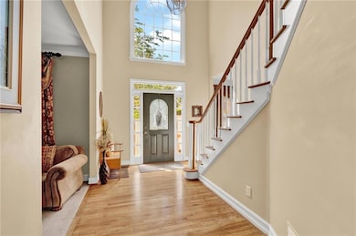 Foyer entrance with wood finished floors, stairs, 