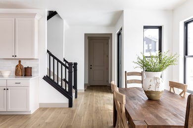 Dining area with light wood-style floors and stairway